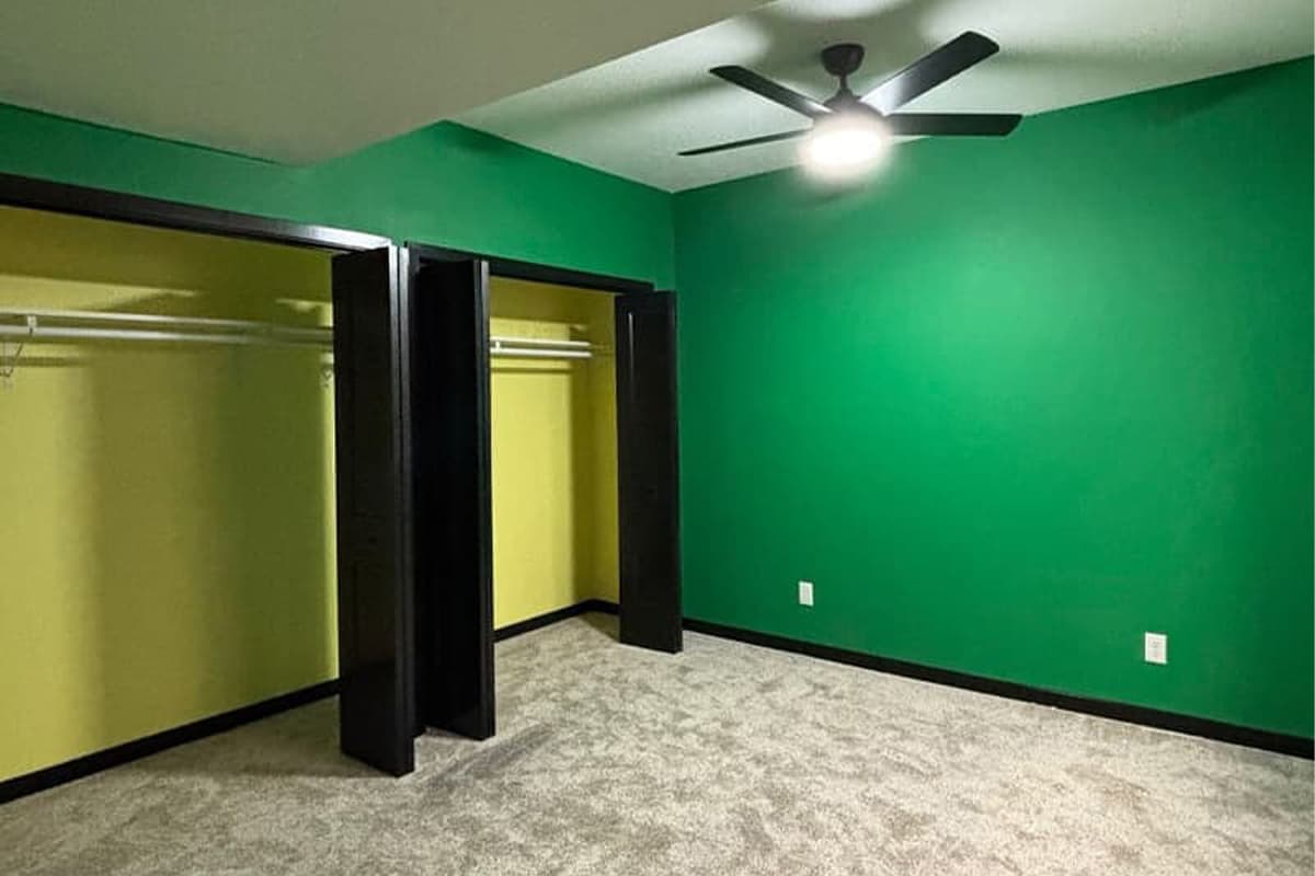 Room with carpet, green walls and closet