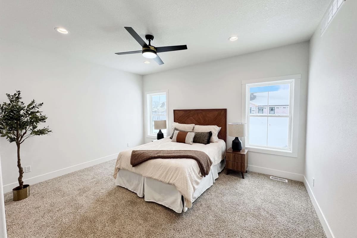 Bedroom with carpet, house plant and windows