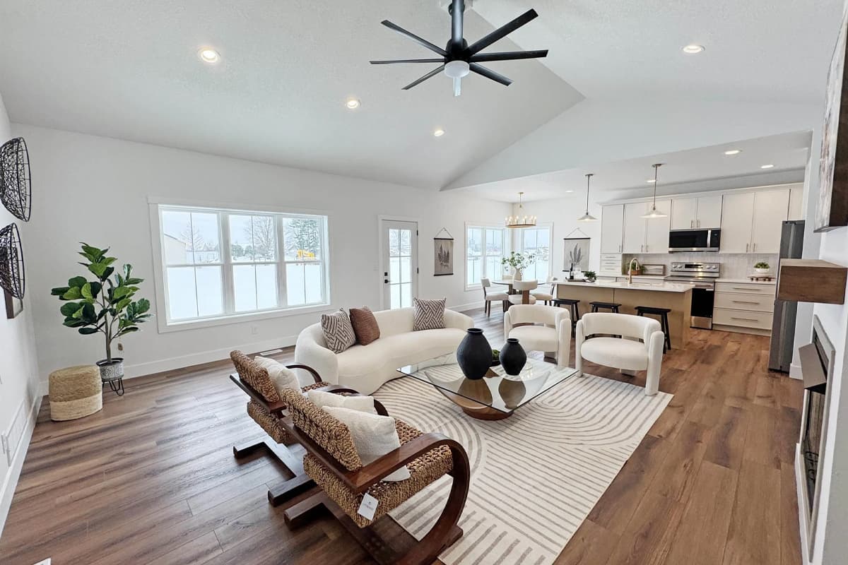 Open living room with wooden floor and light shining through windows
